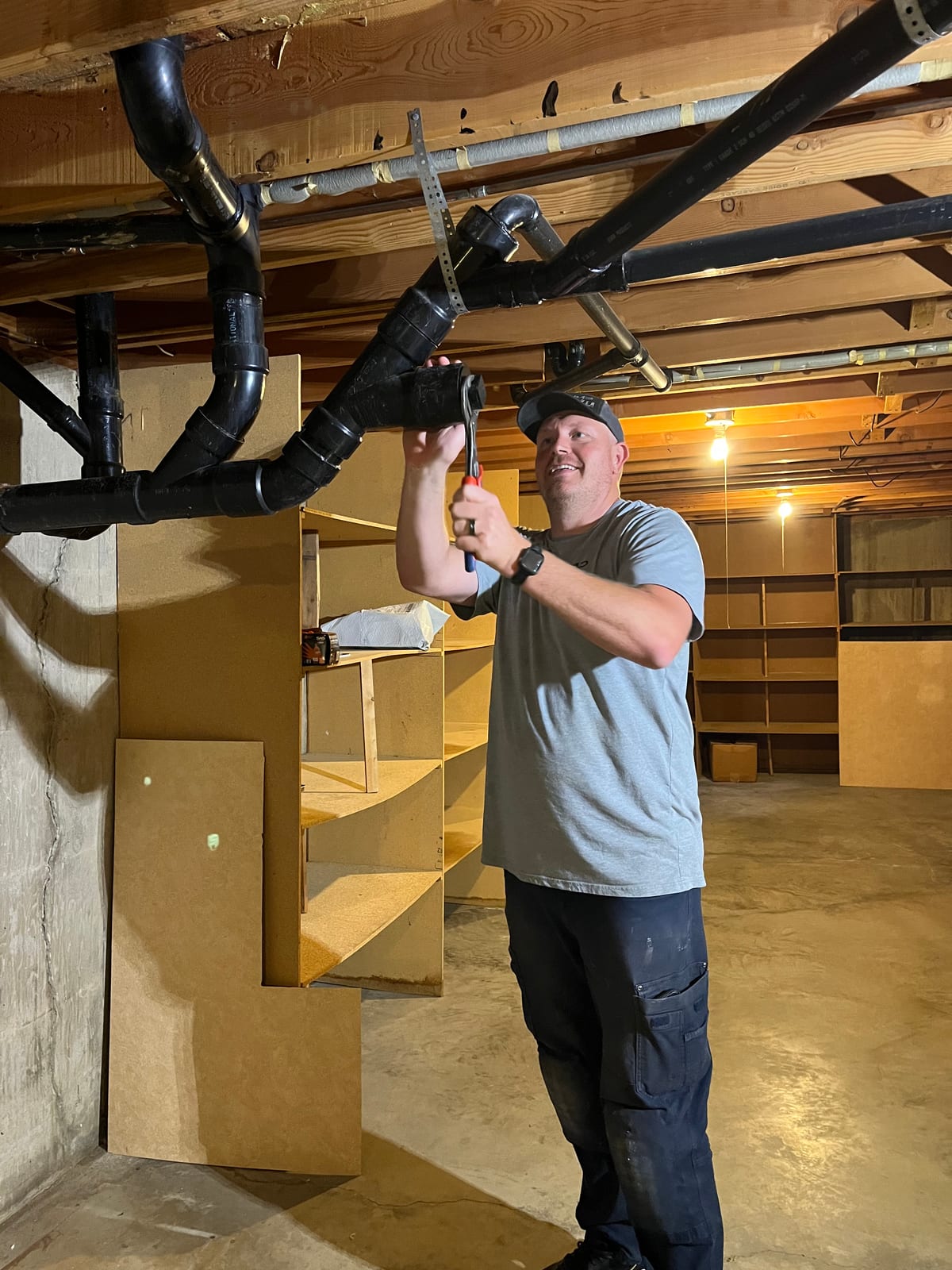 Mayer Plumbing technician working on overhead drain piping