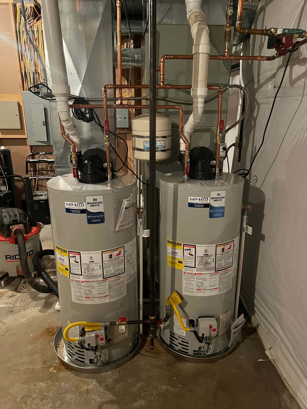 Two power-vent water heaters with copper piping and a shared expansion tank
