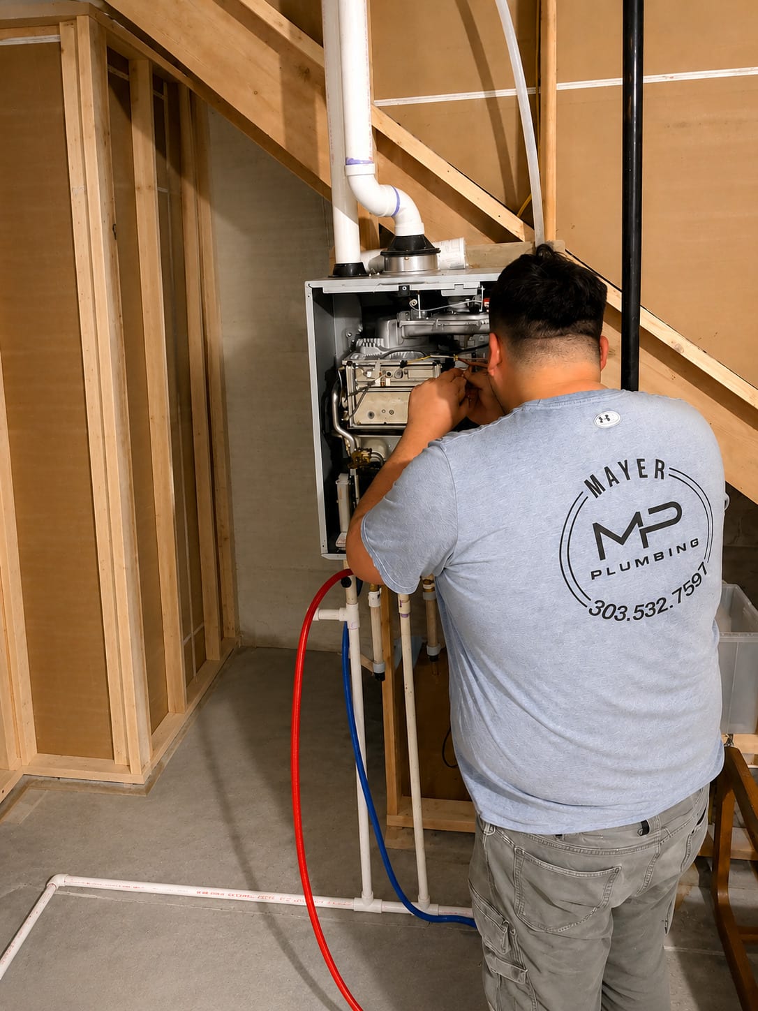 Mayer Plumbing technician servicing an open tankless water heater